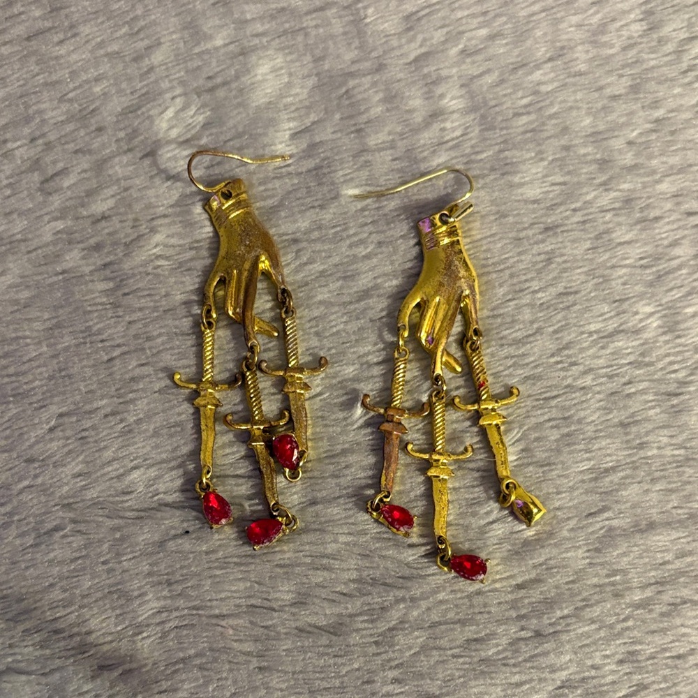 Spencer's Gold Hand Dangle Earrings with Red Accents